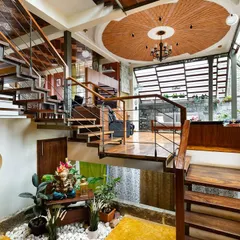 This angle shows the intricate network of staircases that connect the different areas of the home. The design creates an open, flowing experience, where you can see from the ground floor courtyard all the way up to the terracotta-tiled ceiling.