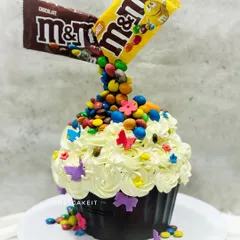 This giant M&M gravity-defying cupcake is a colorful and fun creation. The tiramisu-flavored cake is topped with frosting and a cascade of real M&M's for a whimsical effect.
