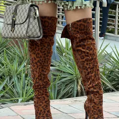 A detail shot of the accessories that completed this look. The leopard print thigh-high boots and the classic Gucci bag are statement pieces that elevate the entire outfit.