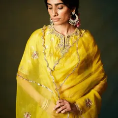 A radiant yellow kurta set in sheer organza. The delicate silver gota patti work and floral motifs add a touch of shimmer to this sunny and cheerful ensemble.