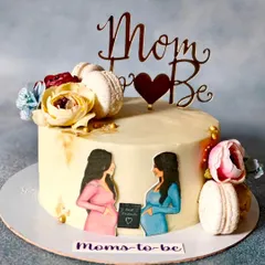 A sweet cake to celebrate two moms-to-be. This design features hand-painted portraits, macarons, and fresh flowers, making it a beautiful centerpiece for a joint baby shower.