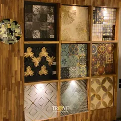 My designer collection features a wide array of patterns. This display includes tiles with gold-leaf accents, intricate Moroccan-inspired designs, and modern geometric shapes, perfect for creating a statement.