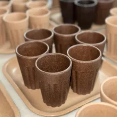 A collection of rustic, eco-friendly chai cups and trays. Made from sustainable materials, these are perfect for a unique, earthy corporate gift that celebrates Indian tradition.