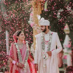 A moment of pure joy as the newlyweds walk hand-in-hand, showered in a cascade of flower petals. We focus on capturing these candid, celebratory moments that define the happiness of your wedding day.