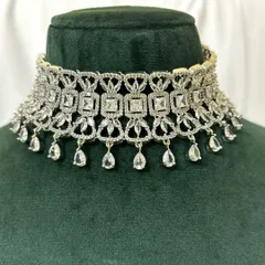 This wide American diamond choker features a geometric pattern and teardrop dangles. It's a bold and modern rental piece.