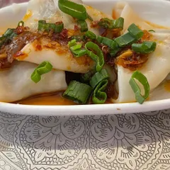 Our handmade chicken dim sum, plated as an appetizer for a sit-down meal. The presentation on an elegant silver-patterned plate adds a touch of sophistication.