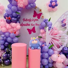 A close-up of the butterfly theme, showing the detail in the organic balloon arch and the custom backdrop that reads "Butterfly is free, Anaisha Turns Three!".