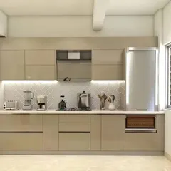 A clean and efficient single-wall kitchen layout. The handleless beige cabinets and integrated appliances create a streamlined look, while the herringbone backsplash adds a touch of modern style.