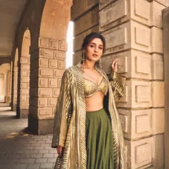 For a modern festive look, we paired a shimmering gold bralette with an olive green skirt and a striped jacket. It’s a contemporary take on the classic lehenga.