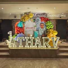 For Atharv's 'Wild One' party, we used large, illuminated marquee letters for his name to create a stunning stage. The setup was completed with a colorful balloon arch and a personalized backdrop featuring his photo.