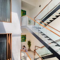 From this angle, you can see how the multi-level staircase interacts with the home's living spaces. The glass railings and open-riser design maintain a sense of lightness and visibility, ensuring the home feels connected across all its floors.