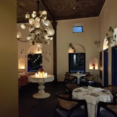 The ambiance at night is one of quiet sophistication. The interplay of our unique chandelier, soft candlelight, and architectural details creates a truly memorable dining environment.