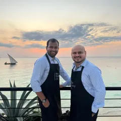 Our founders in Tanzania, with a beautiful sunset over the ocean behind them. This photo captures our passion for bringing the Tipsy Co experience to destination celebrations around the world.