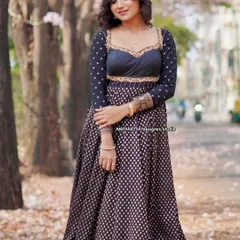 A model in a beautiful black and gold printed Anarkali-style lehenga, perfect for an evening function.