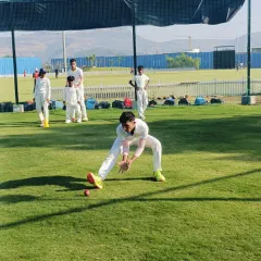A player practices the correct technique for fielding a ground ball, a fundamental skill we instill in all our cricketers.