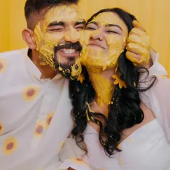 The Haldi ceremony is pure, unscripted fun. I focus on capturing the genuine laughter and playful energy, like this moment where the couple is covered in turmeric paste, completely lost in their joy.