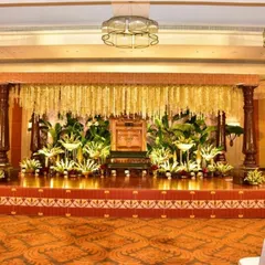 A setting that feels like home, grounded in tradition, yet beautifully timeless. This engagement stage features a canopy of cascading jasmine, lush greenery, and classic wooden pillars, creating a warm and regal ambiance.
