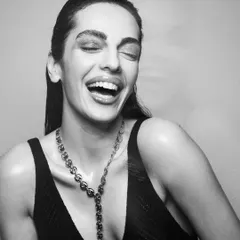A joyful, candid moment that showcases a beautiful, natural makeup look. Even in black and white, you can see the radiant skin finish and clean styling.