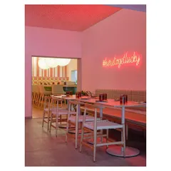 The layout of Lucky Chan was designed as a series of interconnected rooms, reinterpreting the structure of the old house it occupies. A neon sign adds a modern, playful touch to the layered space.