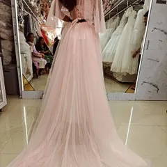 The back view of this custom pink gown shows off its beautiful long train, made from soft, dotted tulle for a touch of whimsical elegance.