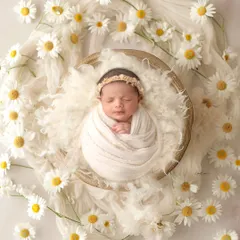 As fresh as a daisy. This sweet girl is surrounded by a field of daisies, creating a pure, simple, and cheerful portrait.