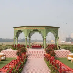 The main mandap for 'A Mughal Garden' wedding, set against the Mumbai skyline. The sage green structure with red accents and a custom-tiled aisle creates a stunning contrast.