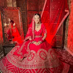 The perfect traditional red bridal lehenga for your big day. This piece features heavy embroidery and a classic silhouette, paired with a beautiful green-beaded Kundan necklace set, all available for rent.