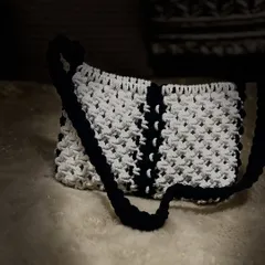 The detailed knotting on this white and black shoulder bag makes it a true piece of art. It’s a versatile accessory for any fashion lover.