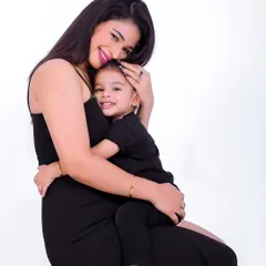 A warm embrace between a mother and her son. This simple and clean studio portrait on a white background focuses entirely on their loving bond and happy smiles.