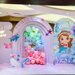 We created an enchanting 'Under The Sea' world for Samara's birthday. The stage features pastel-colored backdrops, cute sea creature cutouts like an octopus and whale, and a large light-up number '6'.