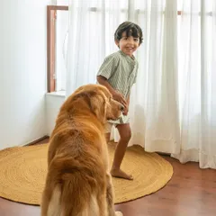 That fleeting smile you can't plan for. After a bit of playtime, Sumer flashes a joyful, genuine grin at his best pal Ziggy. My goal is to capture these real, unposed expressions that show the true connection between kids and their dogs.