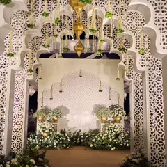 This entrance for a 'Noor-e-Ishq' Sufi night captures the essence of Mughal grandeur. The intricate white jaali arches, adorned with delicate floral strings and brass lanterns, created a poetic and royal welcome for guests, transporting them to a world of timeless romance.