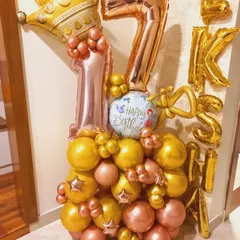 A close-up of a 17th birthday bouquet in rose gold and gold tones. It includes number '1' and '7' foil balloons, a large crown, and a "Happy Birthday" message balloon.