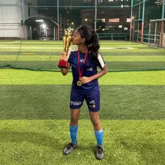 A champion's kiss for the trophy. One of our U17 girls celebrates winning the Girls Youth Football Championship, a moment of personal triumph and team success.