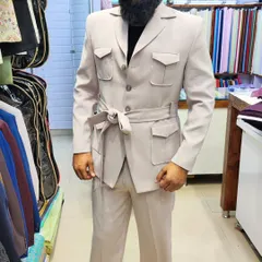 A full view of the client in his beige safari suit, a perfect ensemble for a destination wedding or a stylish daytime event.