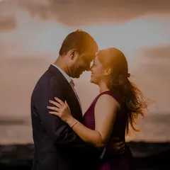 A beautiful silhouette of Akshay and Kiran against a golden sunset over the sea. This intimate, close-up shot captures the warmth and romance of a beach evening.