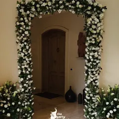 A stunning floral arch made entirely of fresh white carnations and greenery framed the entrance, creating a classic and elegant statement piece for the wedding decor.