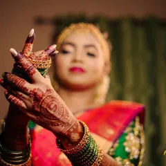 A close-up on the bride's hands, adorned with intricate henna and bangles. These details are an essential part of the bridal story.