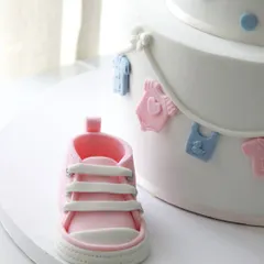 A close-up of the incredibly detailed, handcrafted pink fondant baby shoe.