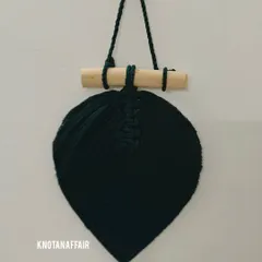 Another dark green macrame leaf on a wooden dowel. These simple pieces can add a touch of nature-inspired boho decor to any room.