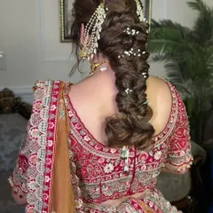 This voluminous, messy fishtail braid is perfect for a bride who wants a romantic and slightly undone look. I added strands of pearls and a traditional 'passa' for a touch of glamour.