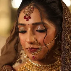 A close-up of a bridal makeup look, focusing on the shimmering gold and bronze eyeshadow. I used glitter to catch the light beautifully, adding a touch of glamour to the traditional look.