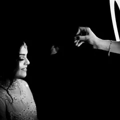 A creative black and white bridal portrait using a ring light to create a unique framing effect, highlighting her serene expression.