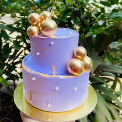 I love creating these mini two-tier cakes for intimate New Year celebrations. This elegant lavender cake is decorated with gold spheres and pearl details for a touch of glamour.