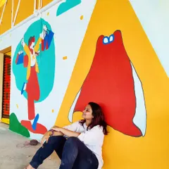 Taking a moment to rest and reflect beside a colorful, abstract mural. Every canvas is a journey, and we pour our emotions and stories into each one.