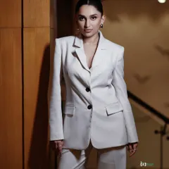 Power dressing is an attitude. For this studio portrait, we went for a clean, sharp look with a white power suit. The focus is on the confident posture and direct gaze, creating a 'boss mode' vibe that’s both elegant and strong.
