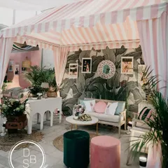 I love bringing a unique theme to life, like this "Hotel California" retro brunch. We recreated the iconic Beverly Hills Hotel cabana, using Martinique wallpaper, custom striped awnings, and personal photos to tell the couple's story with a cool, coastal vibe.