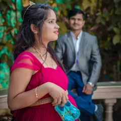 A creative outdoor portrait with the mom-to-be in focus, holding baby shoes. Her partner in the background adds depth to the photo, telling a story of their shared journey.