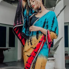 A high-fashion pose that brings a modern edge to the traditional saree. The bold colors of the tie-dye fabric are the star of the show, complemented by the model's strong and confident expression.