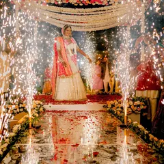 A bride's grand entry on a mirrored aisle, surrounded by cold pyro, as she walks towards the mandap. We design these moments to be absolutely breathtaking.
